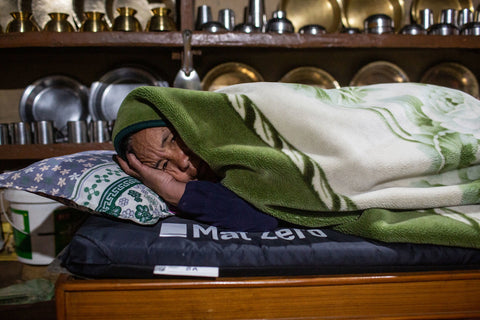 A woman named Ash Maya Gurung warming herself up using MAT ZERO in Tangting Village, Nepal.&nbsp;